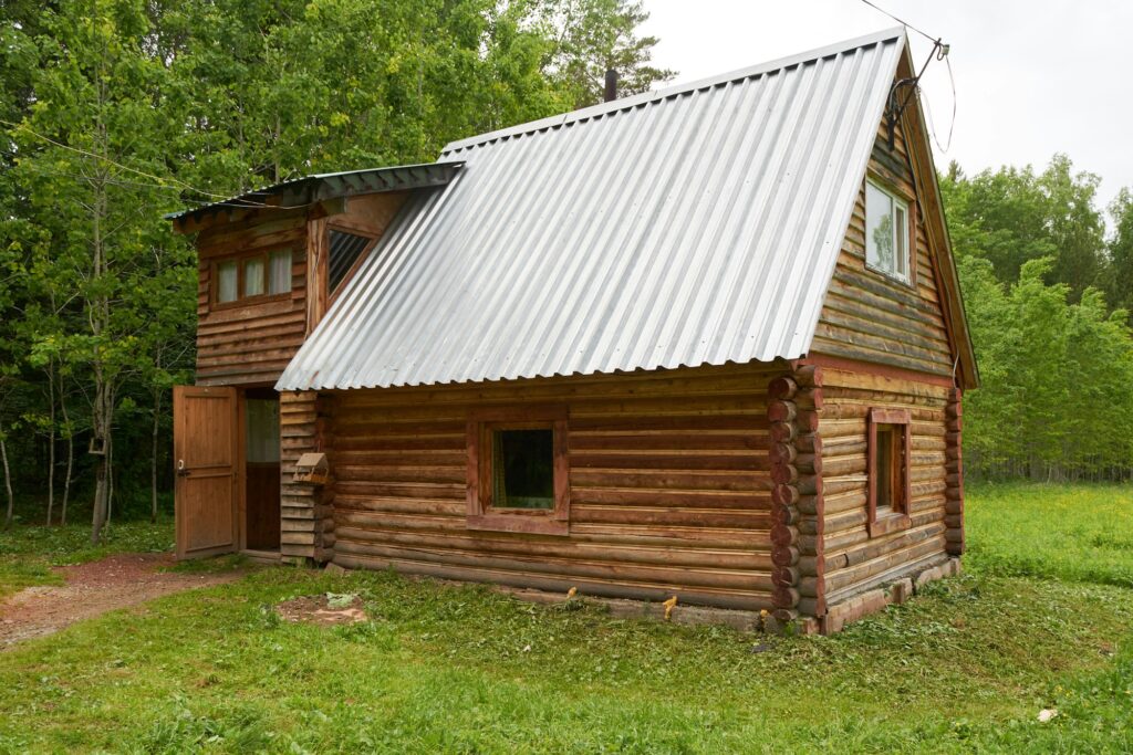 log house in green forest in summer
